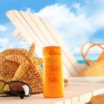10129833 – sunblock lotion and accessories on table at the beach