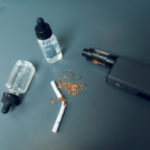 Boxmod, liquid and a broken cigarette lie on the table.