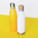 Stylish reusable eco-friendly stainless steel thermo bottles on yellow background.