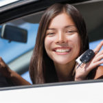 Happy Asian girl teen driver showing new car keys