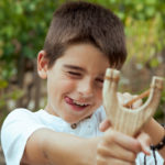 boy with slingshot outdoors