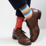 Men’s feet in stylish shoes and funny socks